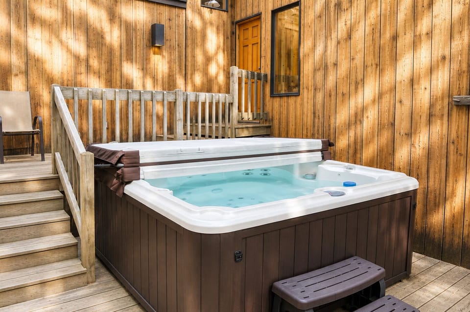 Soak away the day in your private hot tub on the deck, surrounded by warm wood tones and peaceful natural light filtering through the trees.