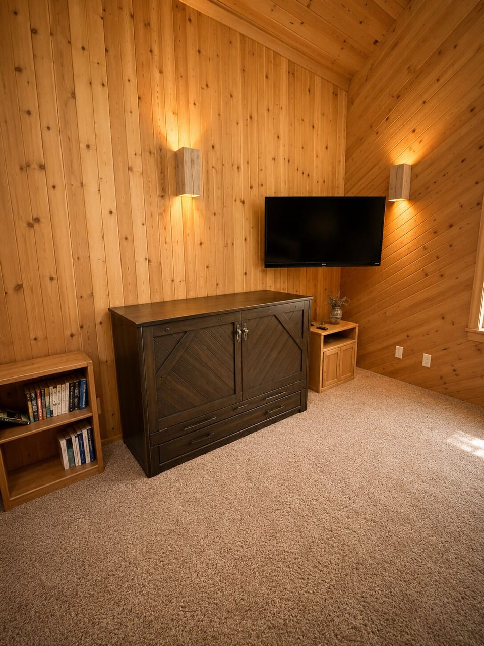 Unwind in your cozy loft bedroom with vaulted pine ceilings, warm ambient lighting, and a flat-screen TV. Plenty of storage keeps your space open and relaxing.