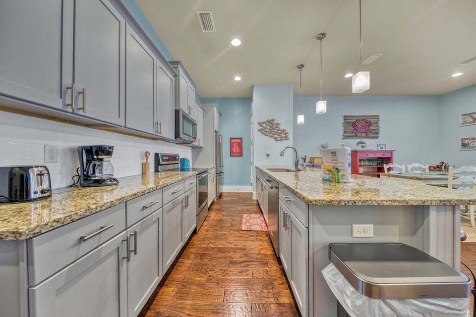 This spacious kitchen features granite countertops, modern appliances, and a large island perfect for preparing meals or gathering with loved ones during your stay.