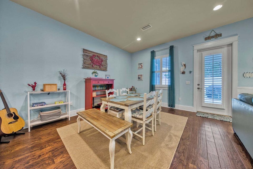 Gather around your dining table with coastal charm, where light blue walls and beachy décor create a welcoming space for shared meals and memories.