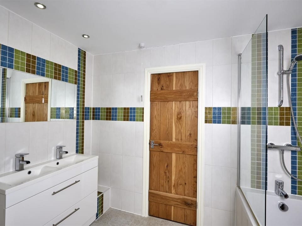 Spacious family bathroom with double sink and shower over deep bath