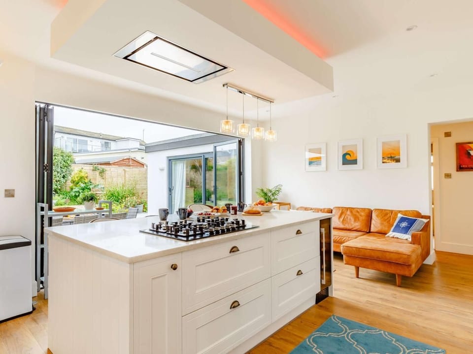 The kitchen is the heart of the house with indoor-outdoor living and a comfy leather sofa