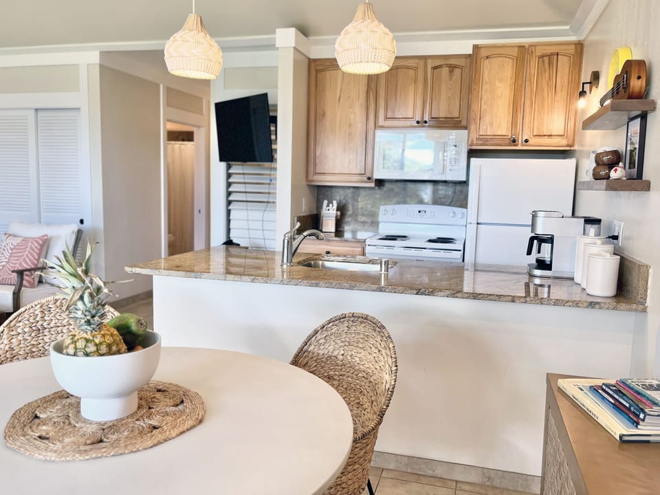 Prepare your favorite local treats in this fully equipped island kitchen, complete with chic woven accents. The open layout ensures you never miss a moment of the breezy, tropical vibe. 