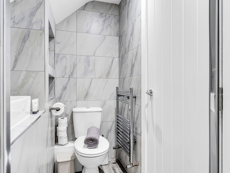 Stylish marble-look bathroom with heated towel rail