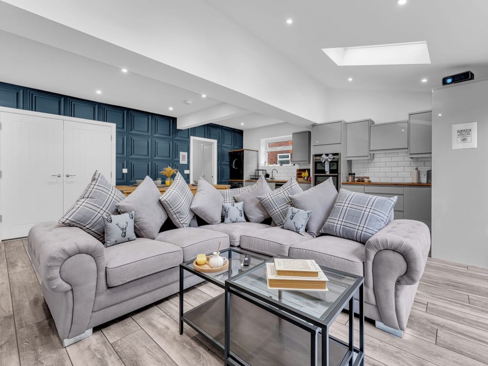 Spacious open-plan lounge with plush sectional and modern kitchen