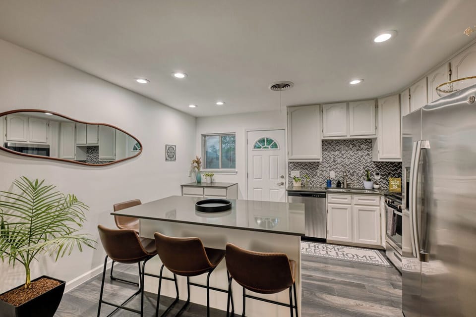Kitchen island and breakfast bar connected to the main living space