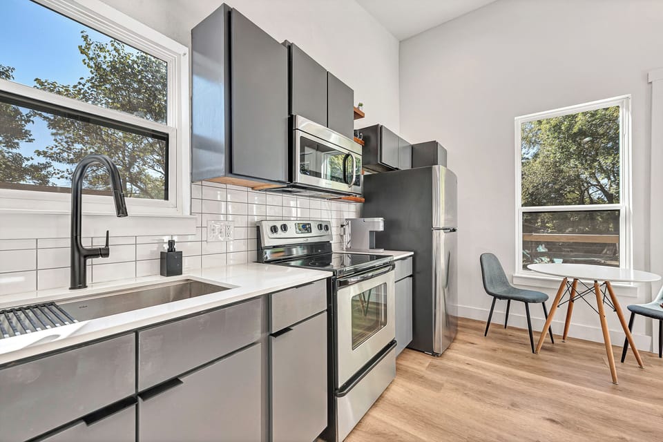 Full kitchen 1
Modern kitchen with stainless steel appliances and dining table.
