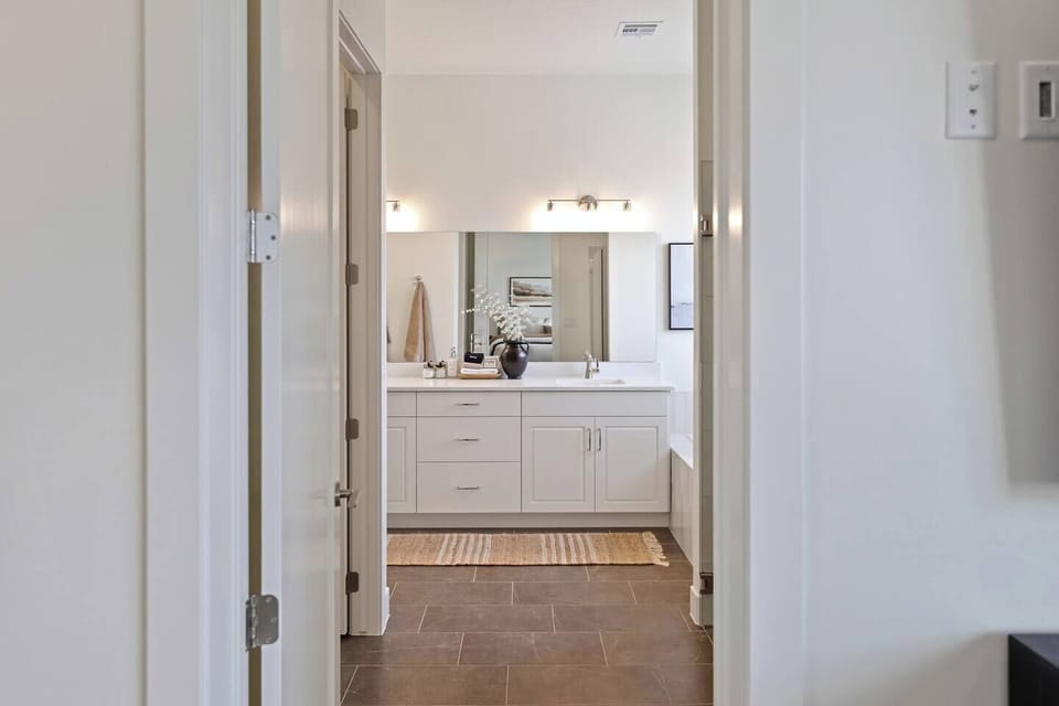 View into the master ensuite featuring a double vanity with dual sinks and a clean, modern design