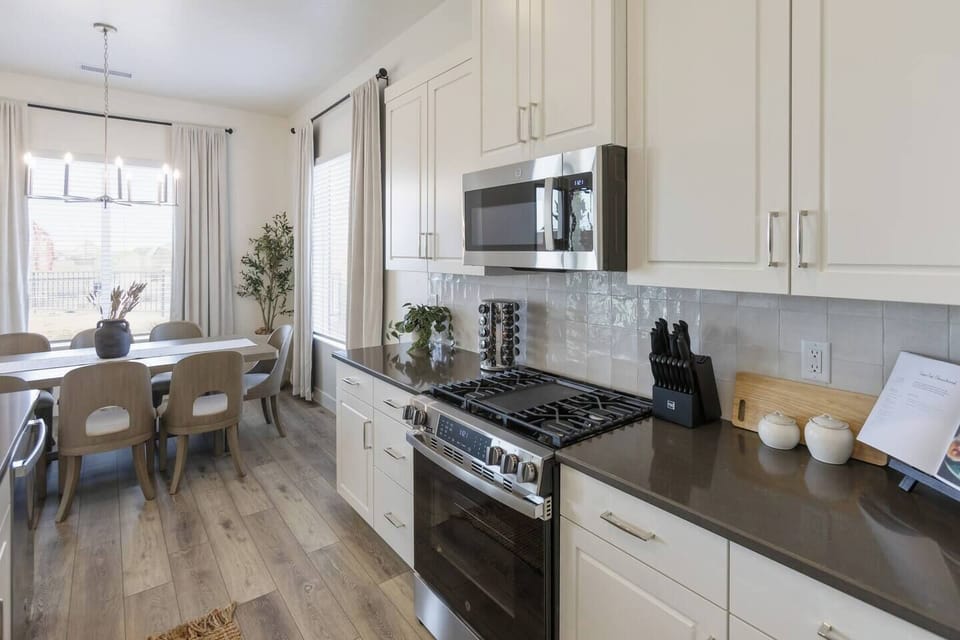 Bright kitchen opening to a dining area with large windows for natural light and a beautiful view!