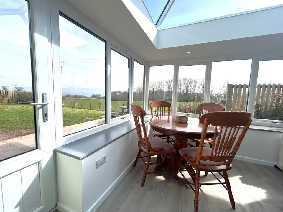 Enjoy dining in the bright and spacious garden room with views across the valley