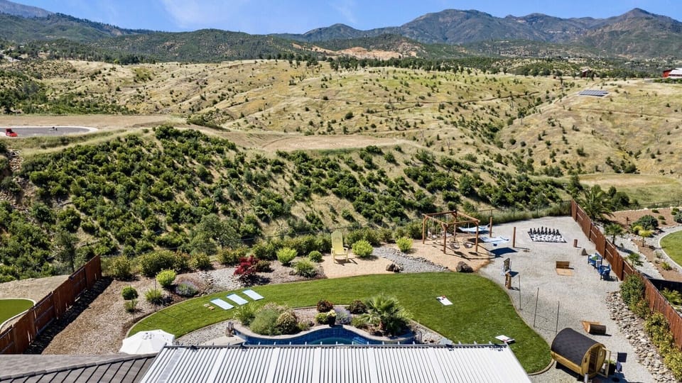 Soak in sweeping mountain and valley views from your private backyard retreat, complete with a pool, lawn games, hammocks, and plenty of space to unwind