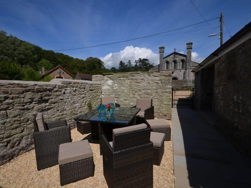 Patio area with seating and a BBQ, with views towards Margam Abbey