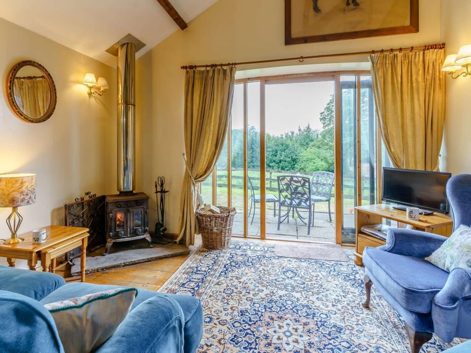 Snug lounge that adjoins the kitchen with a log burner and views over the large garden