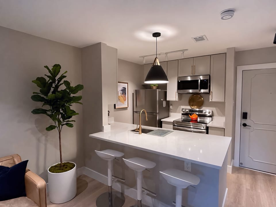 Spacious eat-in kitchen with oversized quartz island and seating for three.
