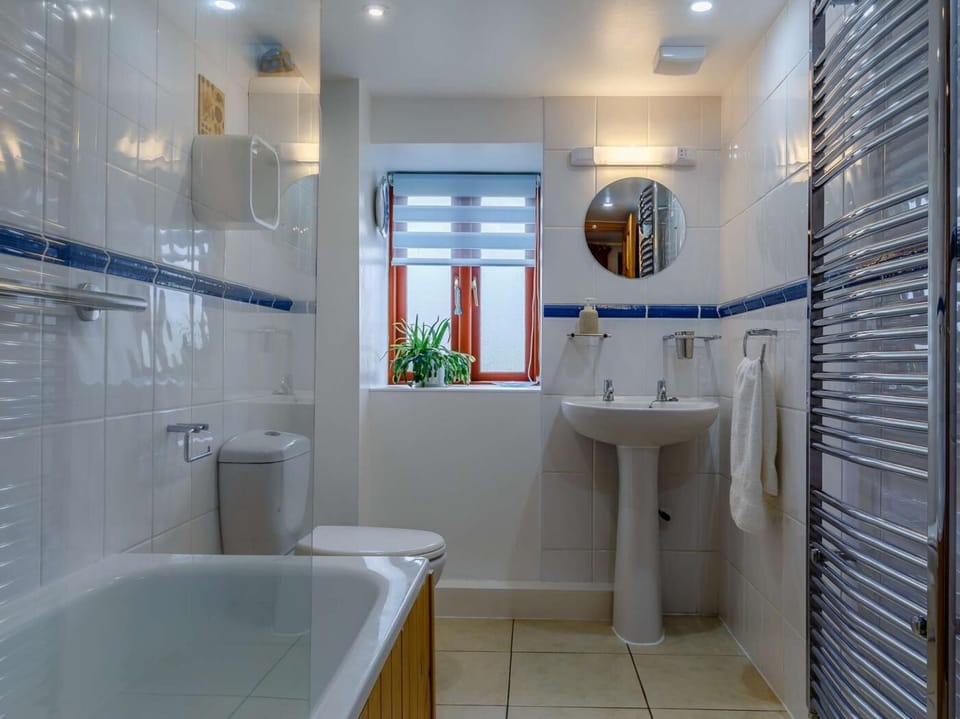 A fmaily bathroom offers a shower over the bath