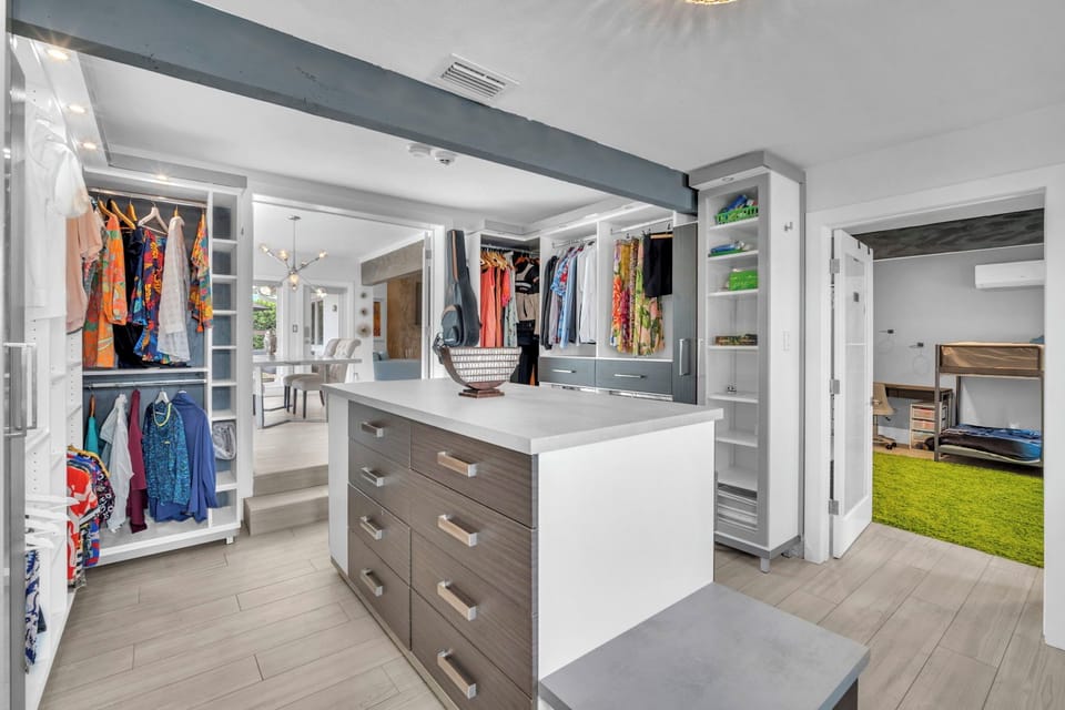 Spacious dressing room with custom storage, a central island, and plenty of room to unpack and settle in.