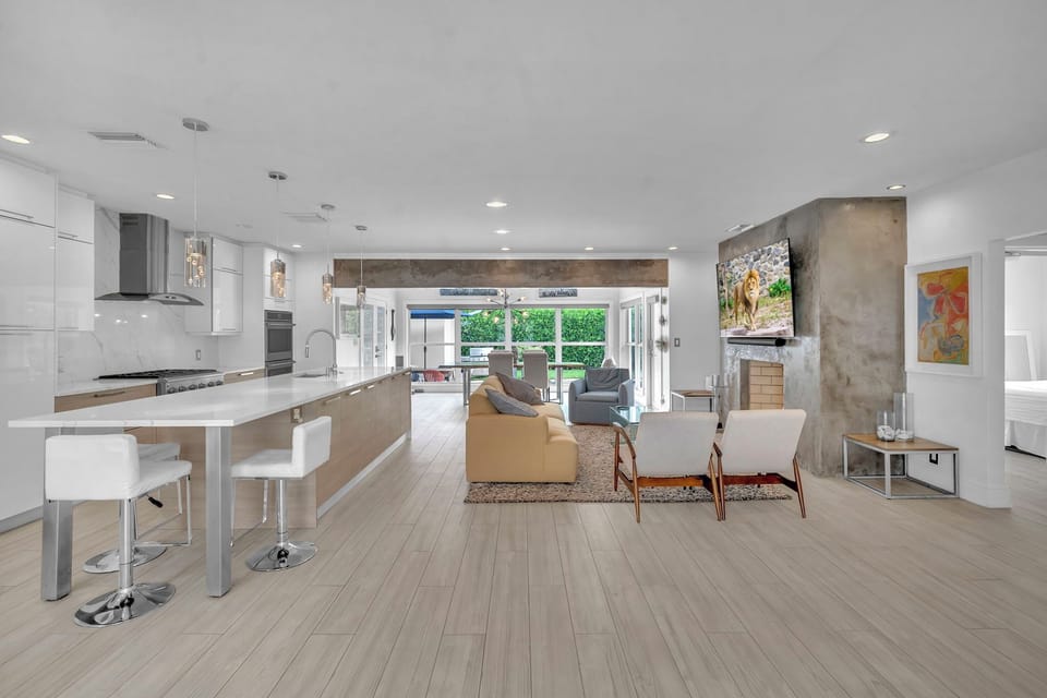Light-filled main living space with a sleek island kitchen, bar seating, and plenty of room to gather.