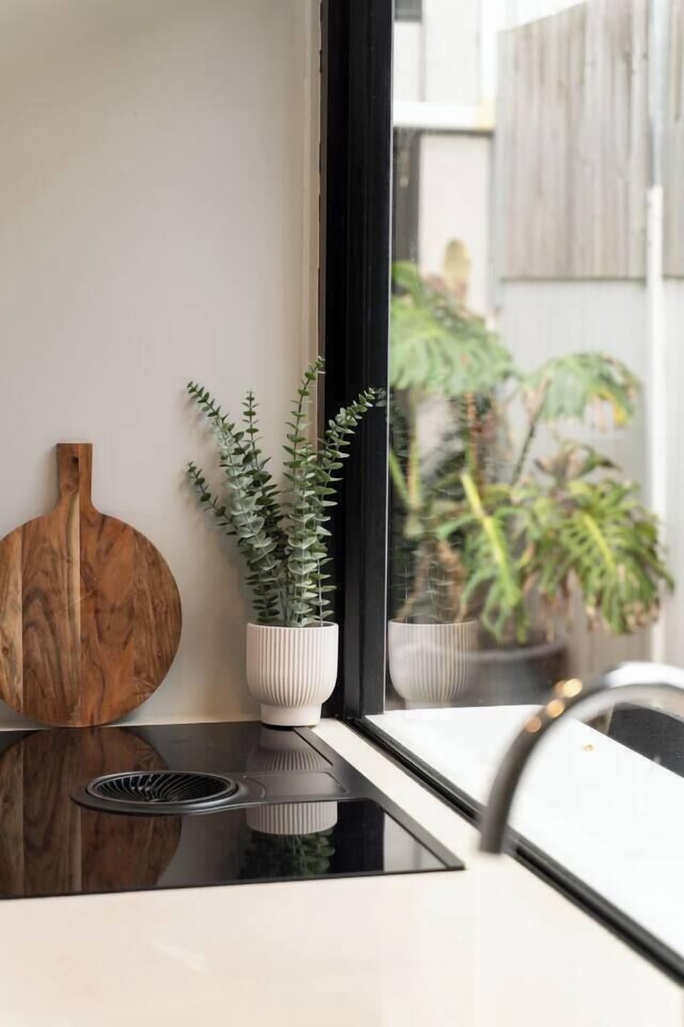 Leafy courtyard views create a refreshing backdrop while preparing meals in the kitchen.