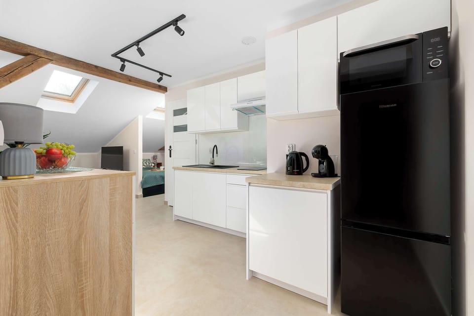 Bright modern kitchenette with full-size refrigerator, ample storage and contemporary appliances.