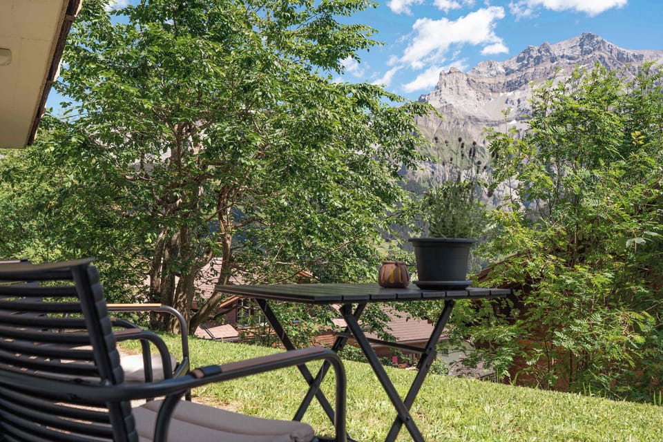 Private garden seating area surrounded by greenery with beautiful mountain views.
