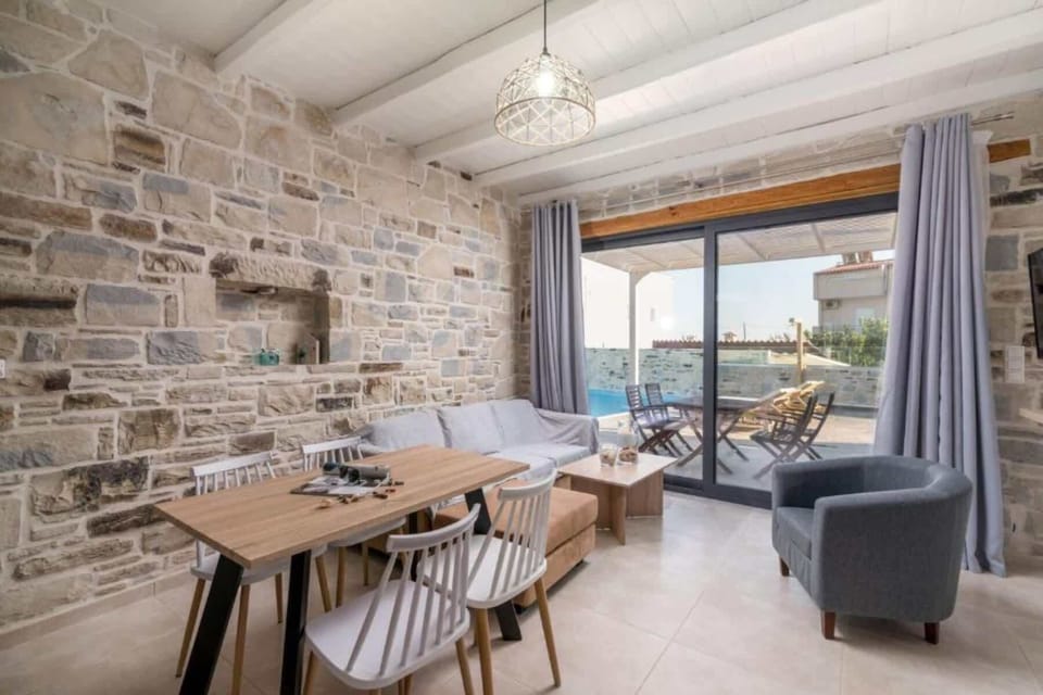 Open-plan living room with elegant stone walls and natural light
