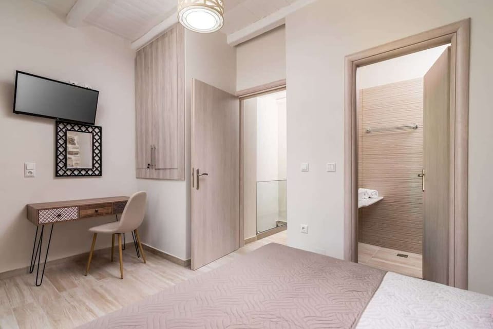 Spacious bedroom with wardrobe, Smart TV, and en-suite bathroom access