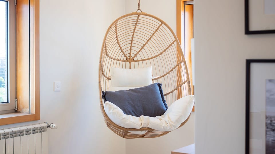 Discover your new favorite relaxation spot in this unique hanging chair, perfect for unwinding with a book or simply enjoying a moment of peace. Natural light creates a serene atmosphere for pure comfort.