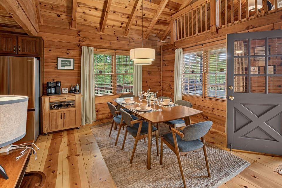 Cozy cabin dining area with deck access, natural light, and seating for 6
