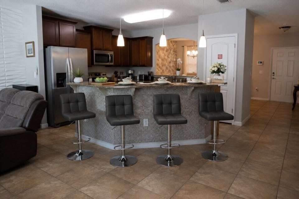 Modern kitchen with breakfast bar and stainless steel appliances for easy dining.