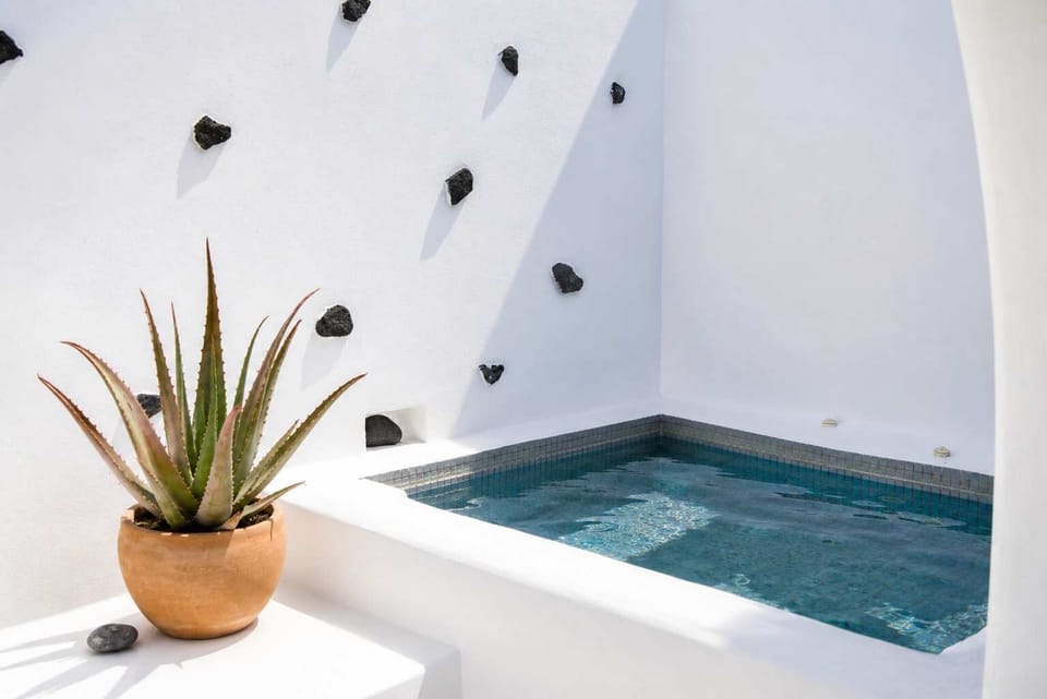Relax in the private heated jacuzzi surrounded by whitewashed island architecture.