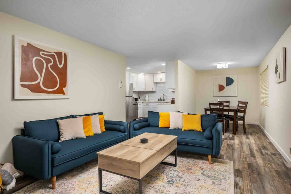 Bright open-concept living and dining area with comfortable seating, a smart TV, and a fully equipped kitchen—perfect for relaxing or gathering togeth