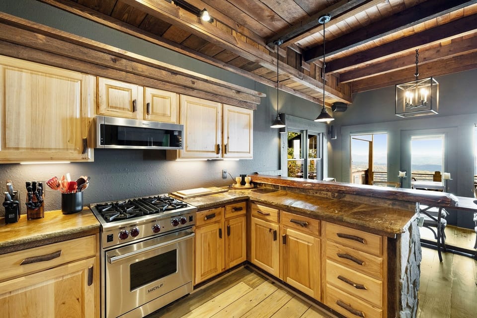 Chop, sear, and pour with the mountains framed in the window. A pro Wolf range and live-edge counter make cooking for the group feel effortless.