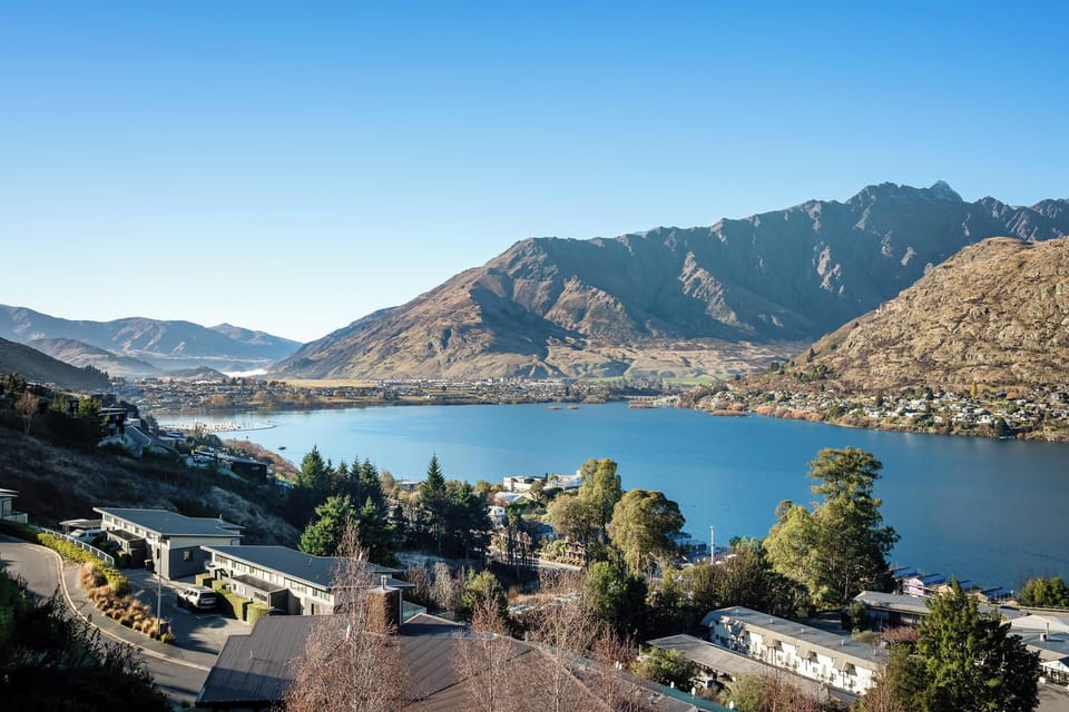 The showstopping view: a sparkling Lake Wakatipu cradled by the jagged, sun-warmed Remarkables, with the Frankton basin spread out gloriously below.