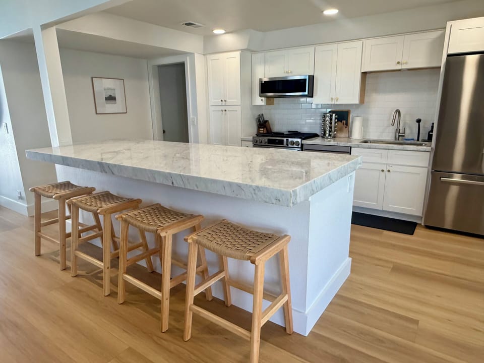 Large kitchen island with marble countertops in open concept kitchen 