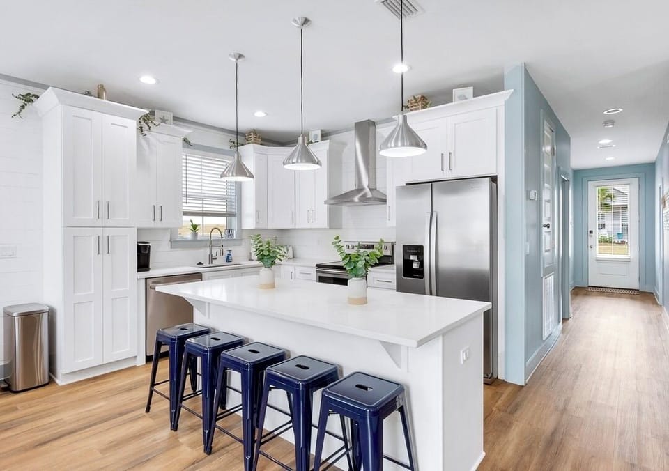 1st Floor - Fully stocked kitchen with quartz countertops, stainless steel appliances, and a large island with seating for 5—perfect for preparing meals and gathering with the whole group!