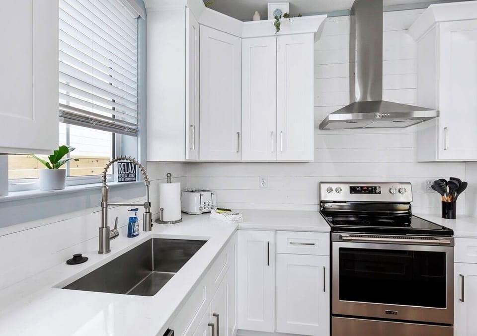 1st Floor - Fully stocked kitchen with quartz countertops, stainless steel appliances, and a large island with seating for 5—perfect for preparing meals and gathering with the whole group!