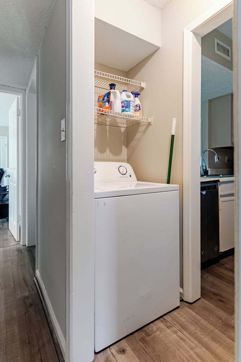 Convenient in-unit laundry nook with washer and storage shelf