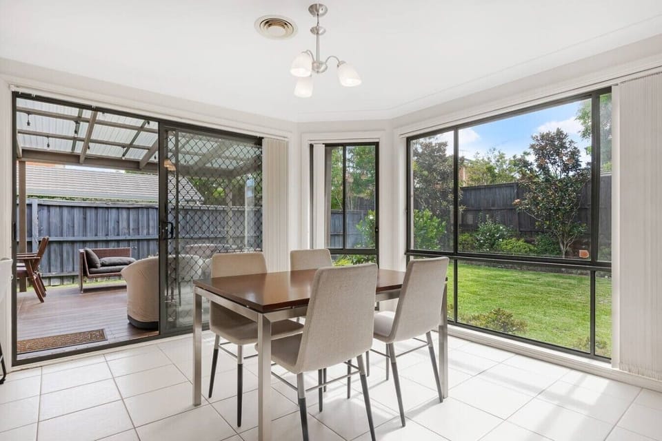 Garden-facing dining area opening directly onto the covered patio and backyard.