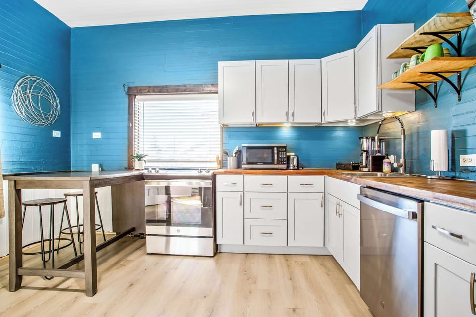 This kitchen space features blue walls and stainless steel appliances.