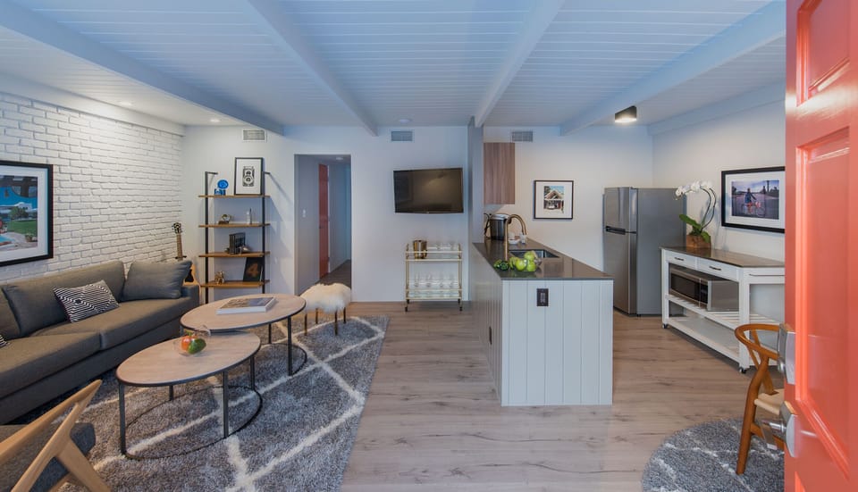 Open-concept suite with a stylish living area, kitchenette, and bright modern finishes.