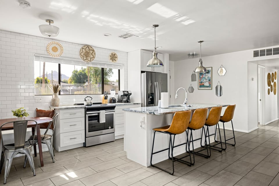 Prepare everything from quick breakfasts to family dinners in the fully equipped kitchen featuring stainless steel appliances, a large island with bar seating, and plenty of counter space.