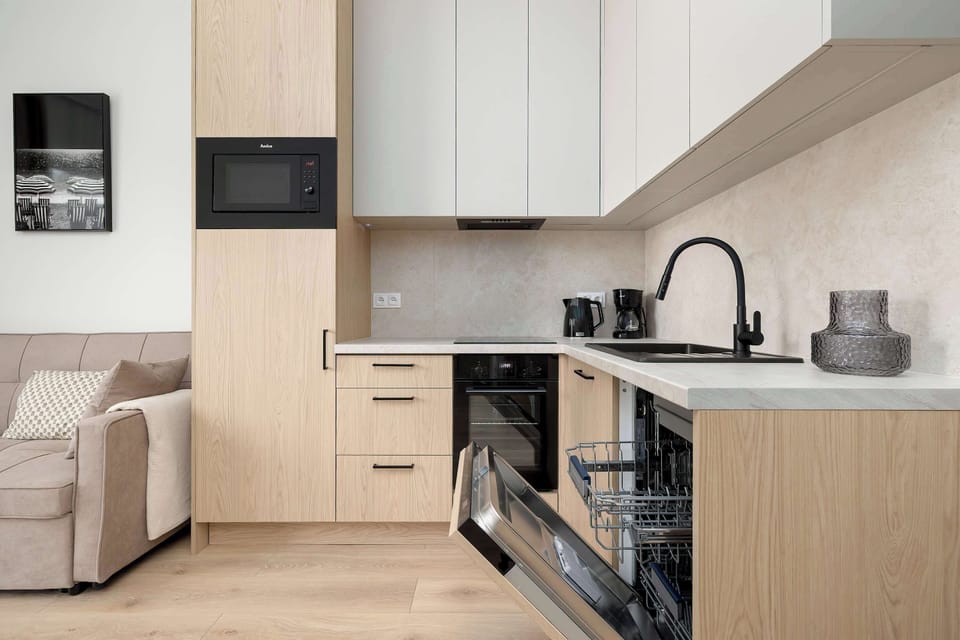 Modern kitchenette with built-in appliances and ample workspace.