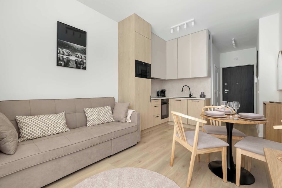 Comfortable seating area with a sofa and fully equipped kitchen in the background.