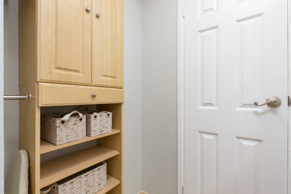 Light wood cabinetry with woven storage baskets keeps your essentials neatly tucked away, adding both function and coastal charm to your space.