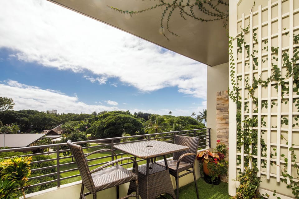 Overlooking lush tropical greenery and open skies, this private balcony offers a serene escape where you can enjoy morning coffee or sunset views surrounded by climbing vines and vibrant plants.
