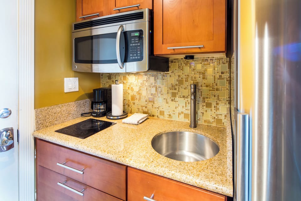 Your kitchenette has everything you need to whip up quick meals: stainless steel appliances, granite counters, a sleek backsplash, and a coffee maker ready for your morning brew.