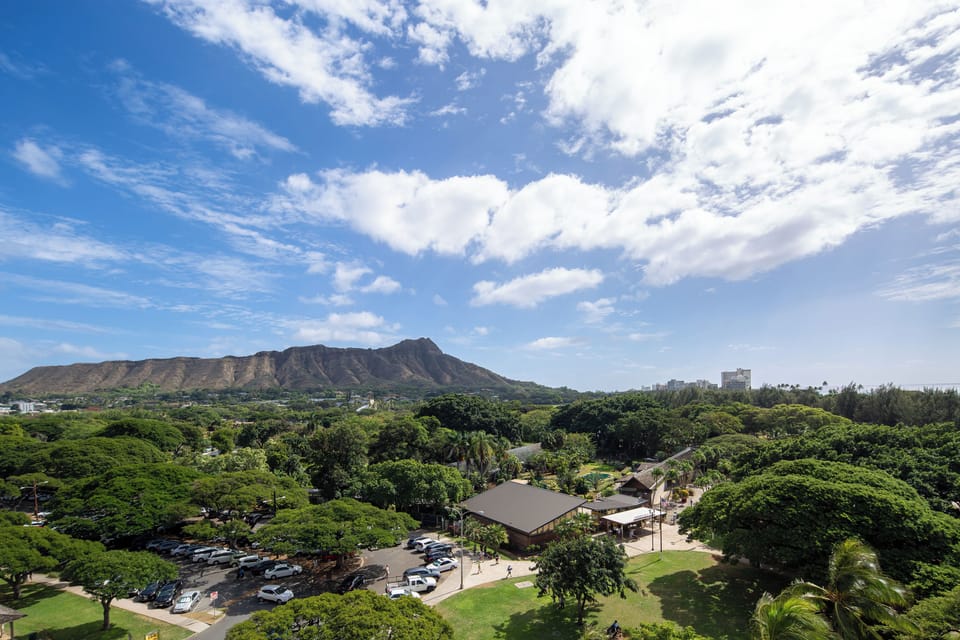 Iconic Diamond Head crater rises majestically beyond lush tropical greenery, framing the property's scenic location in one of Honolulu's most sought-after neighborhoods.