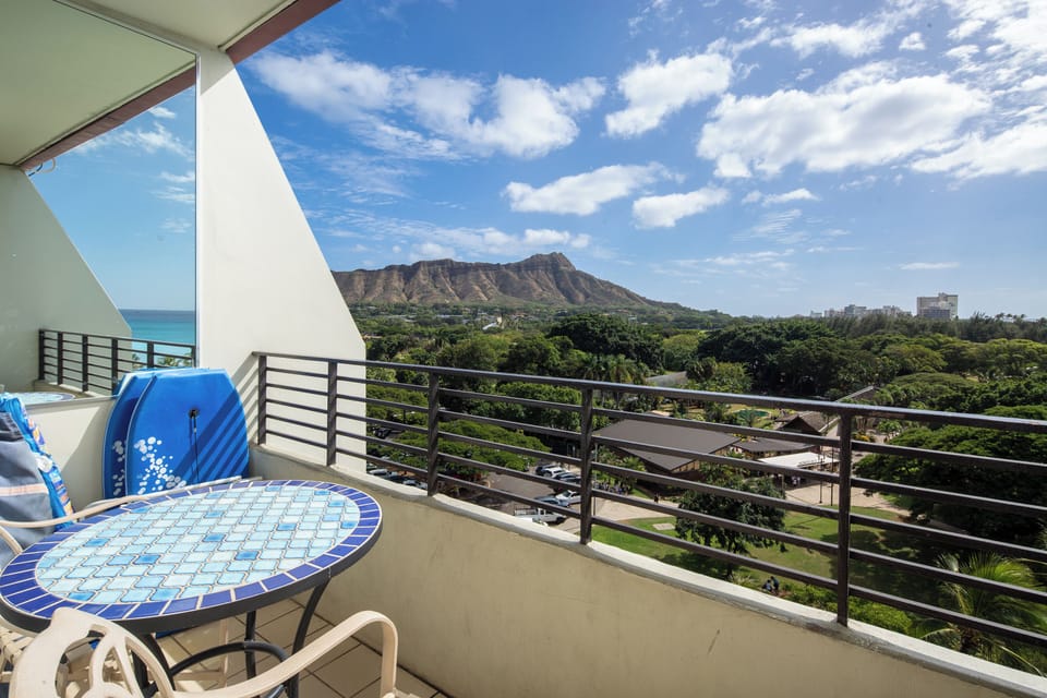 Iconic Diamond Head rises majestically beyond lush greenery, framing a stunning vista from this elevated balcony perch. Your morning coffee tastes even better with Hawaii's famous landmark and endless blue sky in full view.