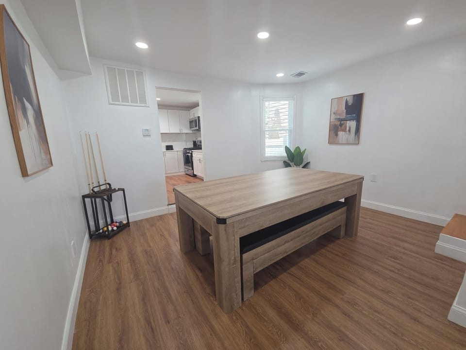 Bright game room with modern pool table next to the kitchen
