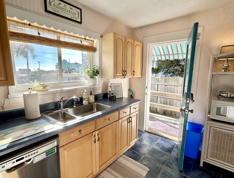 Bright and functional kitchen featuring ample counter space, natural light, and convenient access to the outdoor patio